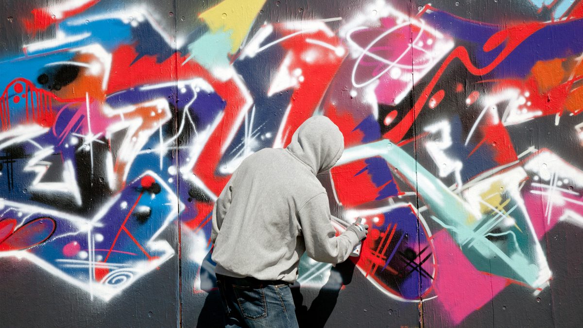 Poika tekee graffitia